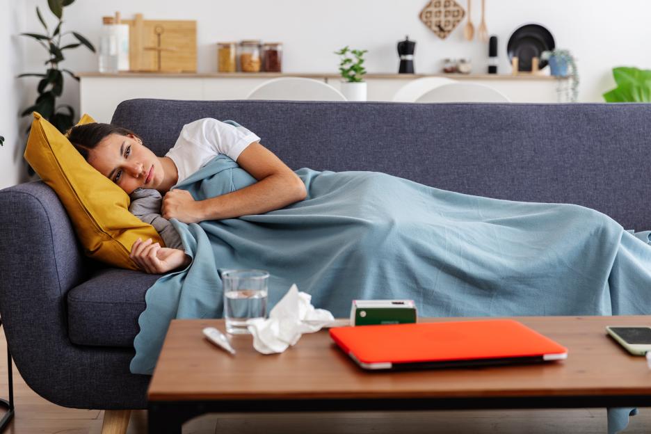 Young woman feeling sick resting at home on couch