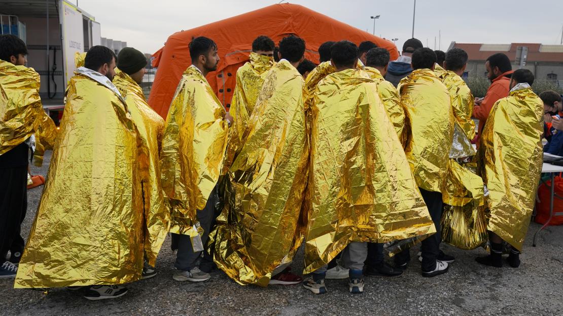 Migrants rescued from a capsized boat in the Channel from France are wrapped in gold thermal blankets in Dunkirk.