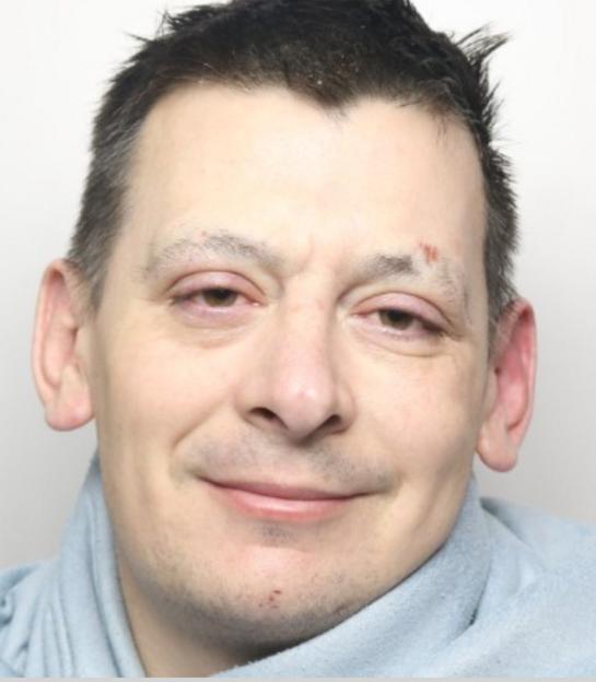 Mugshot of David Oakley, a smiling man with short dark hair, wearing a light blue top.
