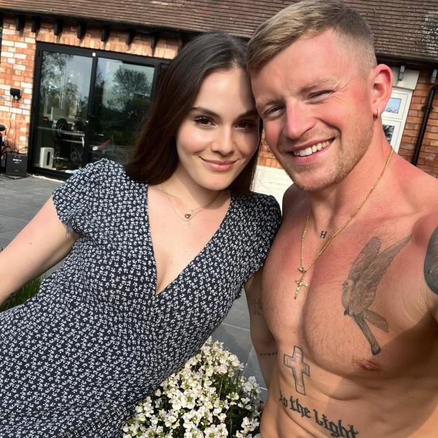 Holly Ramsay and Adam Peatty smiling in an outdoor selfie.