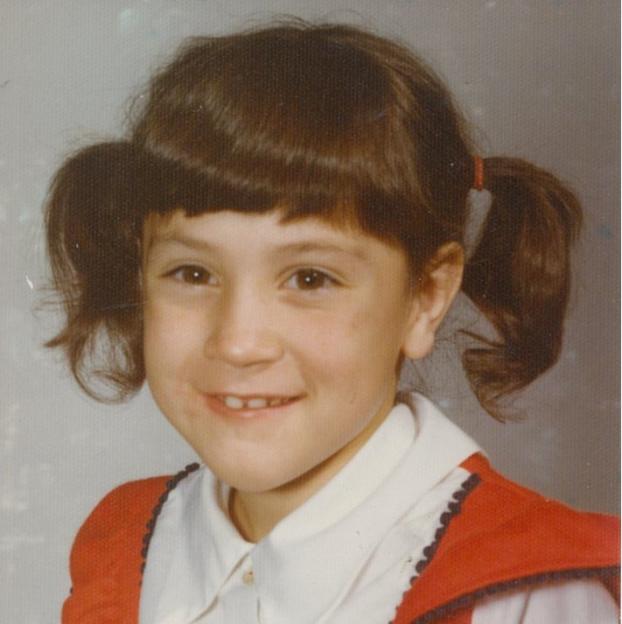 Childhood photo of April Balascio with pigtails.