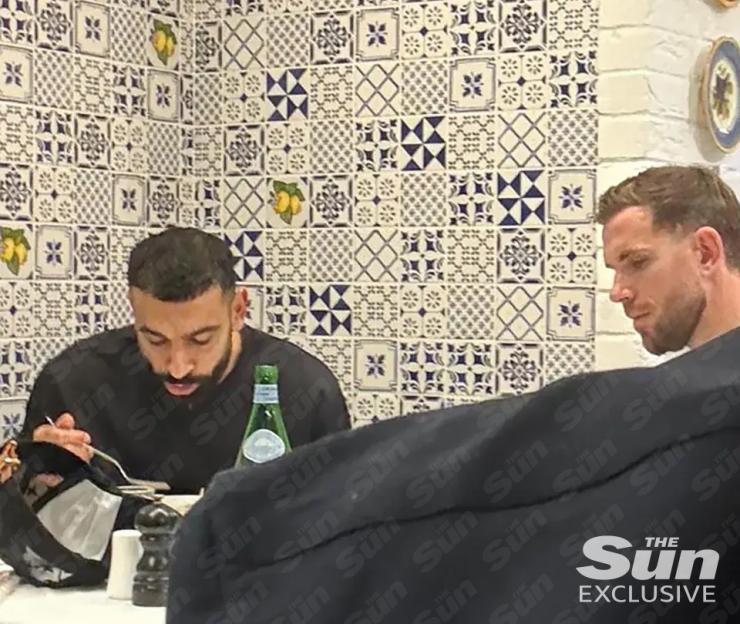 Mohamed Salah and Jordan Henderson dining in a restaurant.