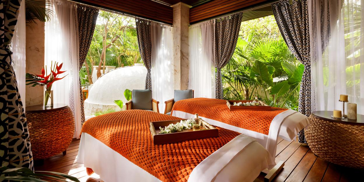 Fairmont Mayakoba spa room with two massage beds and jungle views.