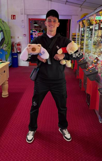 Phil Foden's son, Ronnie, posing with two stuffed animals in an arcade at Golden Sands Holiday Park.