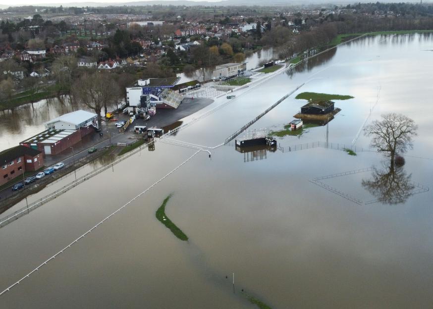 Aerial view of the Worcestershire County Cricket Club under floodwaters with buildings and seating partially submerged.
