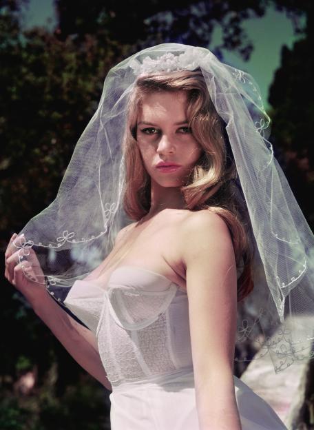 Brigitte Bardot wearing a sheer veil and white bustier.