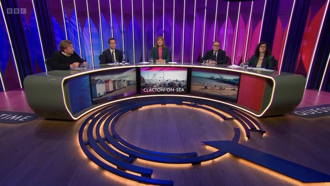 Five panelists sit at a curved desk on the BBC's "Question Time" set, with images of "Clacton-on-Sea" displayed on the desk.