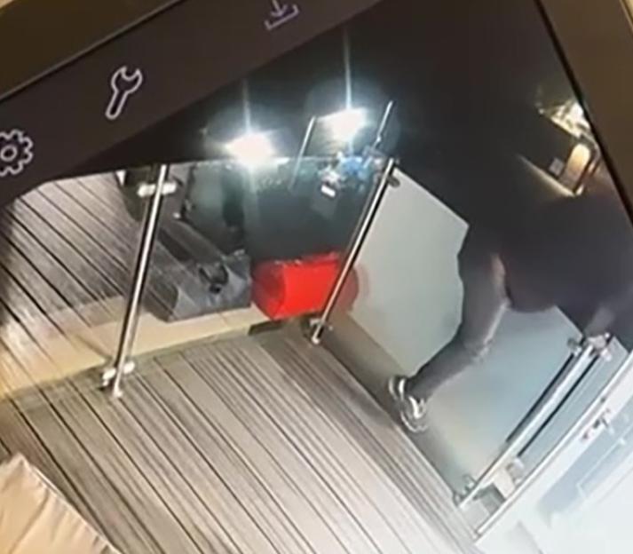 CCTV footage showing two individuals, presumably burglars, with bags of jewelry on a balcony at night.