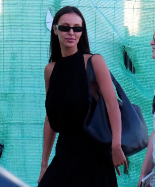 Maya Jama in a black dress and sunglasses arriving at Palma airport.