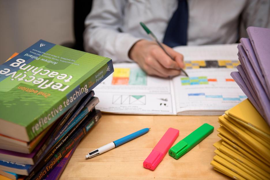 A primary school teacher marking a pupil's English homework.