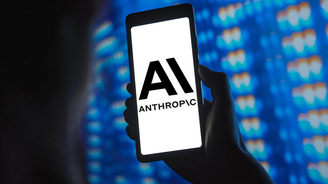 A hand holding a smartphone displaying the Anthropic AI logo.