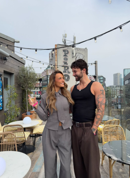 Millie Court with Zac on a rooftop bar.