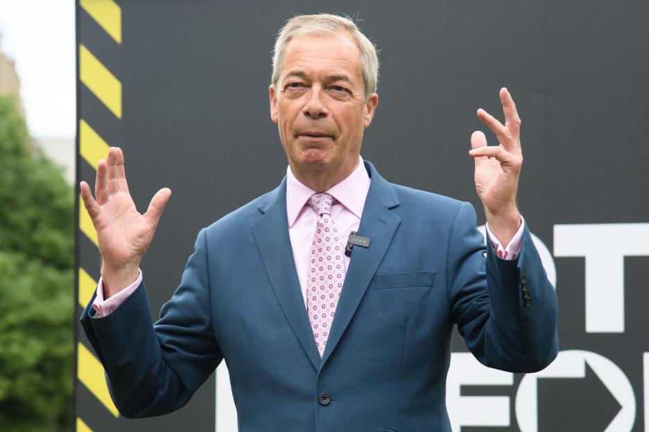 Nigel Farage, leader of Reform UK, gestures with both hands during a local election photo call.