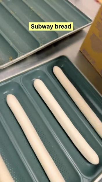 Frozen Subway bread dough sticks in baking trays.