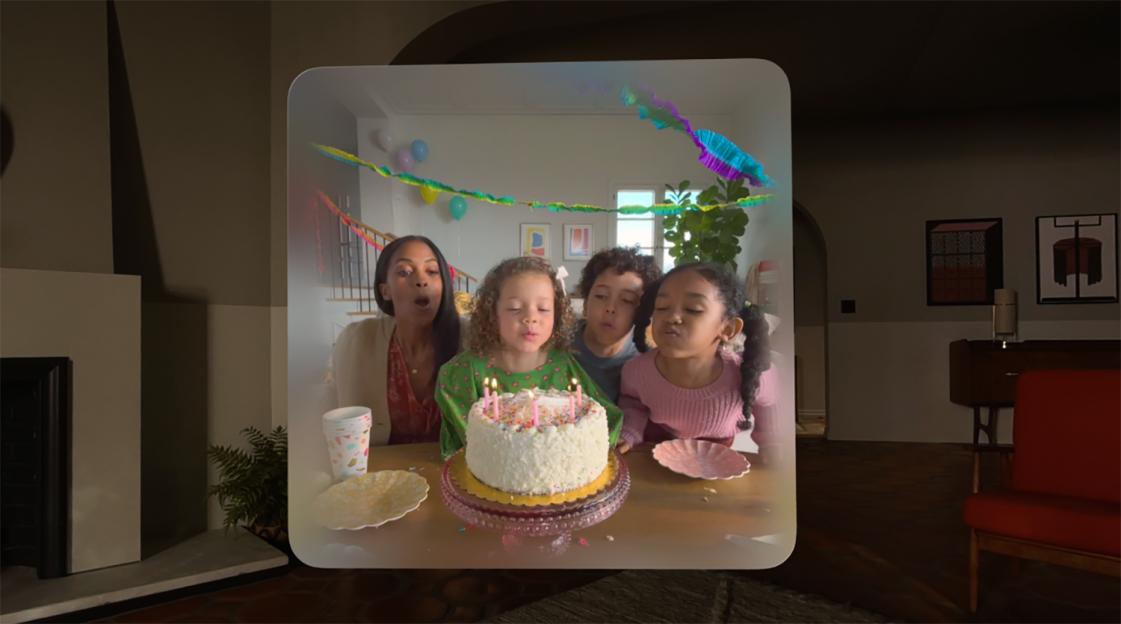 A family celebrating a birthday, blowing out candles on a white cake.