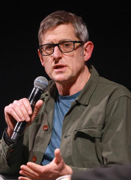 Louis Theroux speaking into a microphone.