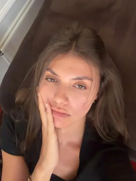 Samie Elishi rests her hand on her cheek while lying down.