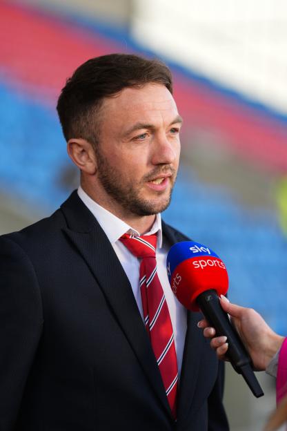 A man in a suit and red tie being interviewed by a Sky Sports reporter.