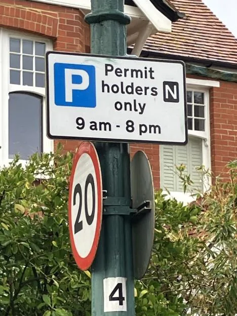 A parking sign on a post reading "Permit holders only N 9 am - 8 pm".