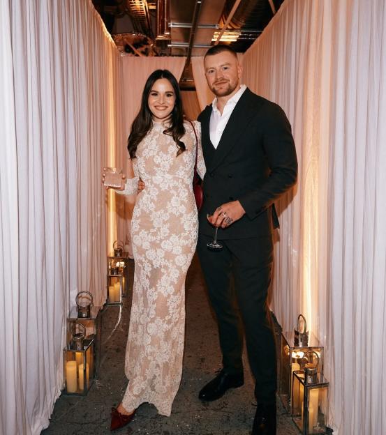 Adam Peaty and Holly Ramsay posing at their engagement party.