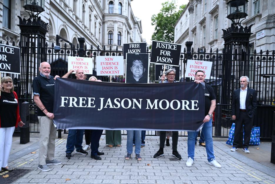 Demonstrators holding "Free Jason Moore" banners and signs that say "New Evidence Jason is Innocent" and "Justice for Jason" in front of Downing Street.