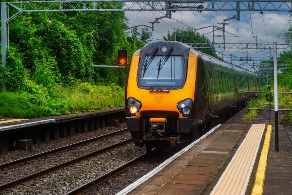 A passenger railway train pulling into a station.