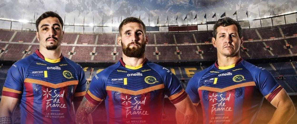 Three Catalans Dragons players in their team jerseys at Camp Nou stadium.