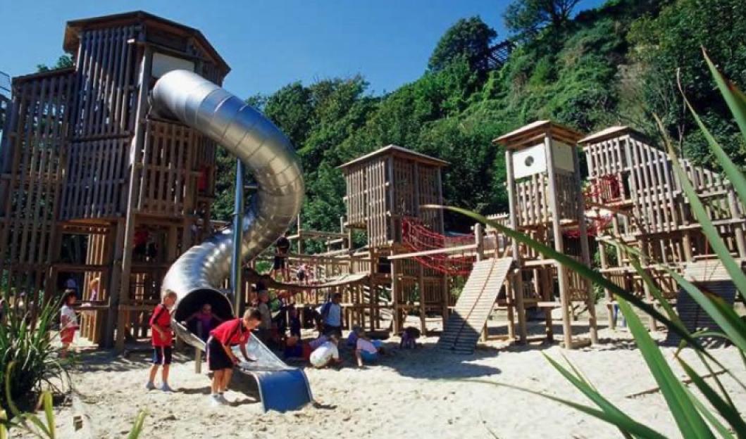 Lower Leas Coastal Park play area featuring wooden structures and slides.