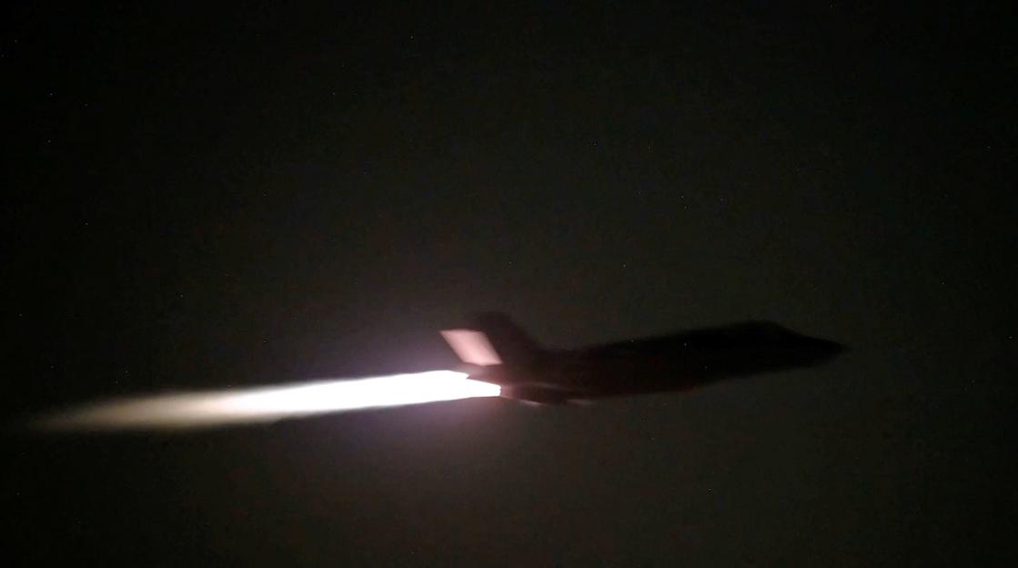 A U.S. military aircraft flies at an unknown location, during what U.S. Central Command says are strikes on Iran