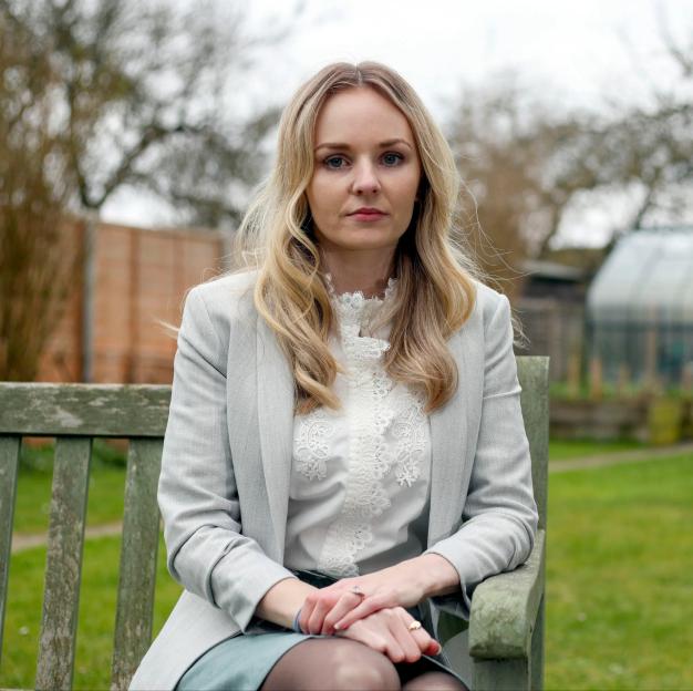 Lissie Harper, the widow of PC Andrew Harper, sitting on a wooden bench in a garden.