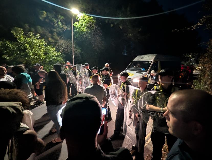 Police officers with riot shields facing protesters near Eastney Beach, Portsmouth.