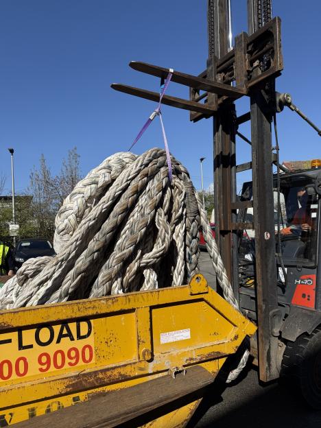 A forklift moving a large coil of thick, braided white rope, part of the "Exhibition of Old Rope" installation by David Shrigley.