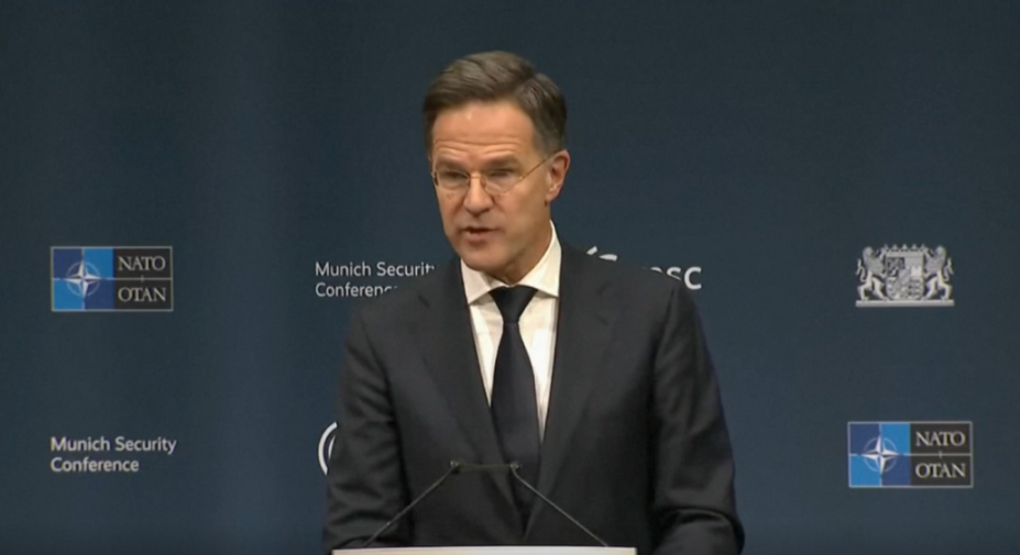 Dutch Prime Minister Mark Rutte speaking at the Munich Security Conference with NATO logos visible.