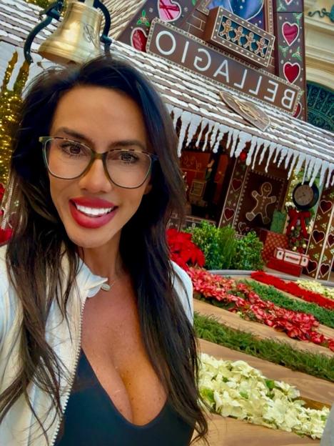 Crystal Janke taking a selfie in front of the Bellagio gingerbread house.