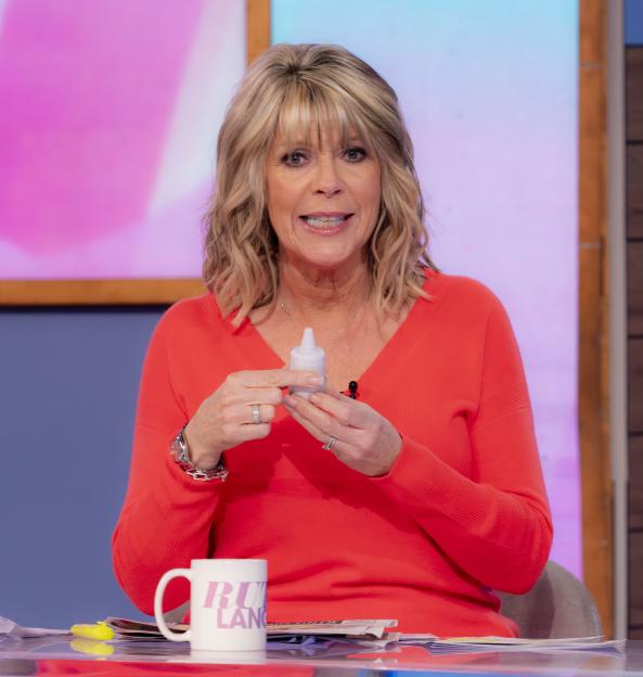 Ruth Langsford holding a small white bottle and smiling.