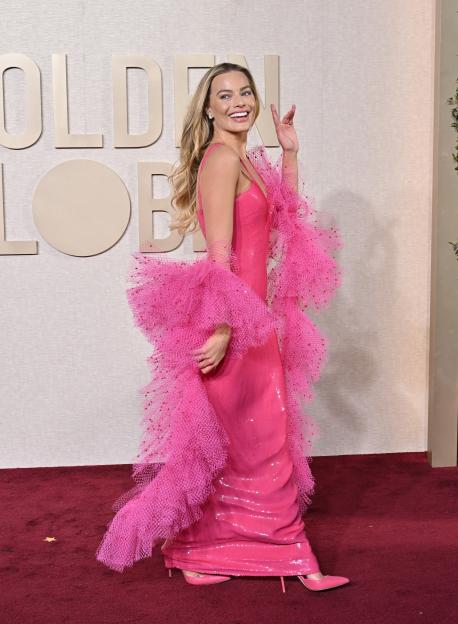Margot Robbie attends the 81st Annual Golden Globe Awards wearing a pink sequined dress with a matching voluminous tulle wrap.