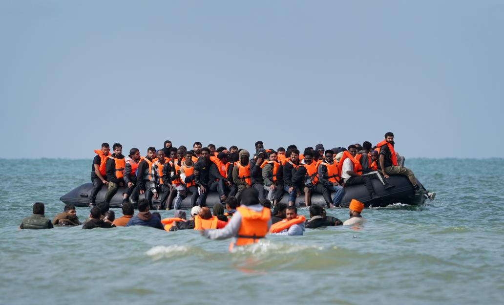 People thought to be migrants attempting to cross the English Channel board a small boat off the coast of Equihen-Plage, France.