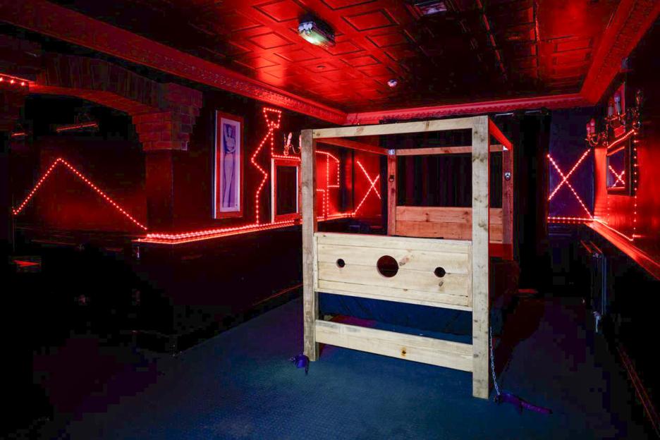 Interior of playrooms at The Mirage with red lighting and a wooden structure.