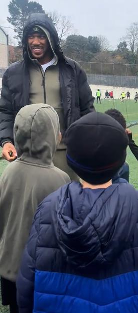 Anthony Joshua smiling at a children's football training session.