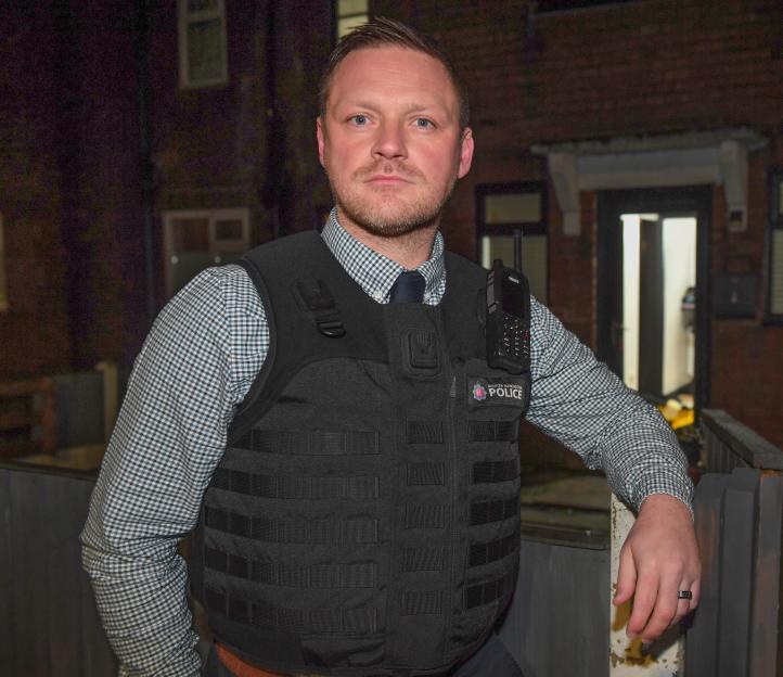Detective Inspector Mark Holt leading a police raid.
