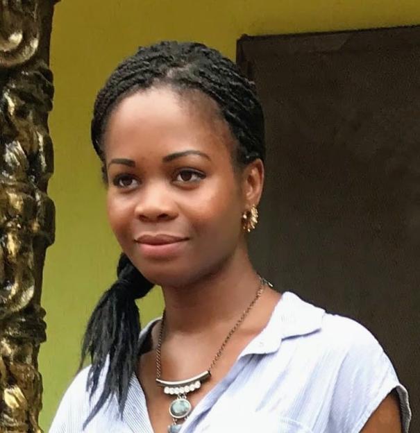 Frances Obiefuleh, with braided hair, wearing a striped shirt and necklace.