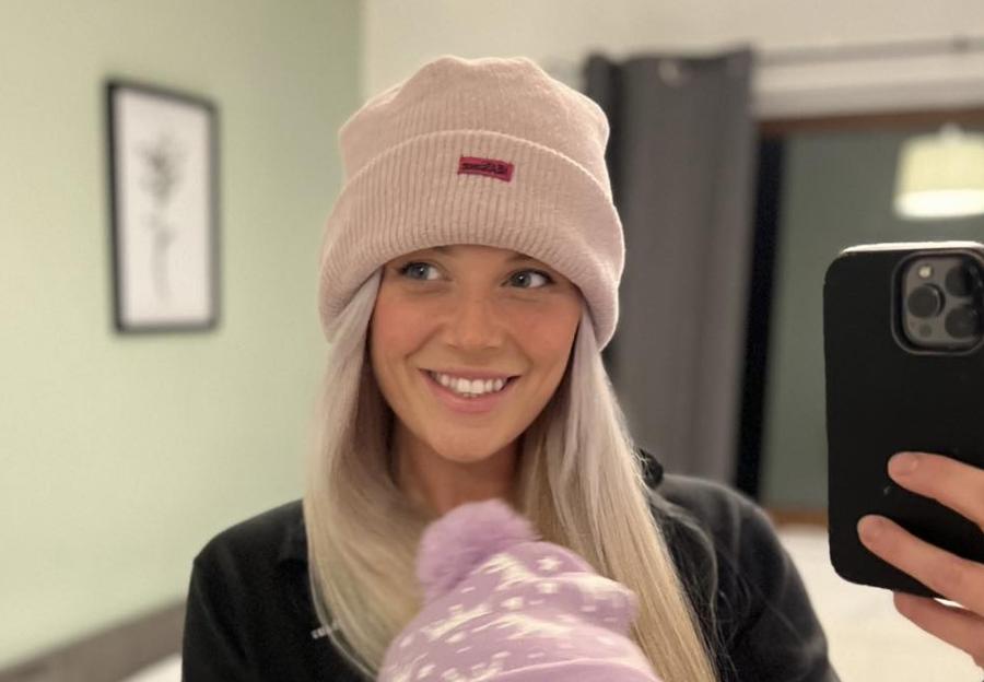 Pamela Pritchard, a police officer, wearing a pink beanie and black top, smiling at the camera.