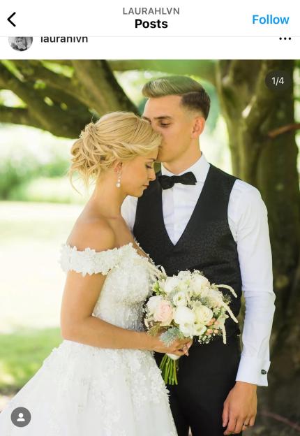 Leandro Trossard kissing his wife, Laura Hilven, on the forehead in their wedding attire.
