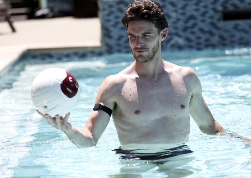 Declan Rice in a pool holding a volleyball during a recovery day.