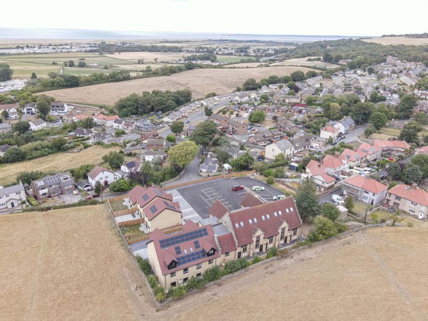 Aerial view of properties in Gronant, North Wales overlooking the countryside and sea.