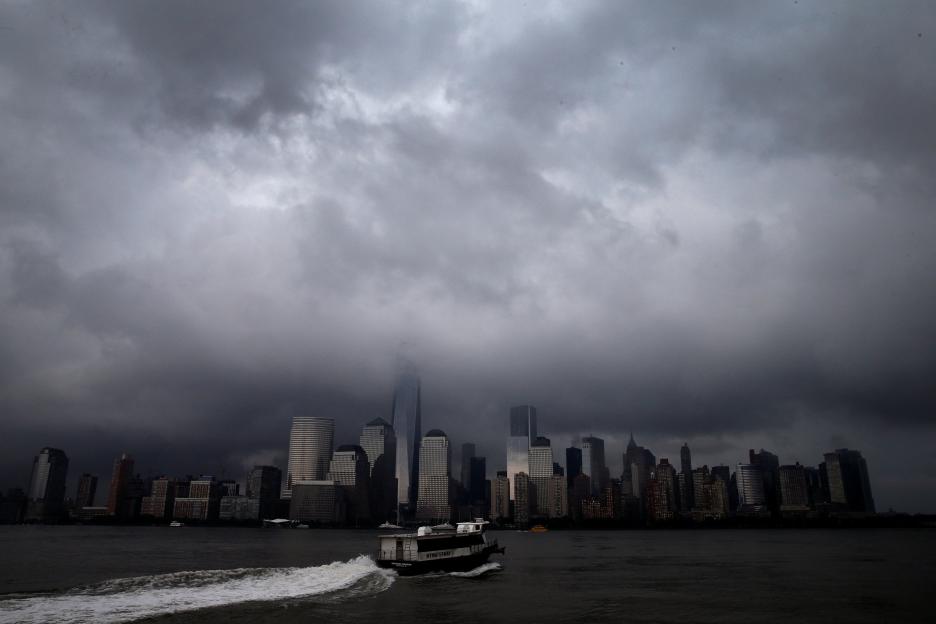 : A ferry leaves Jersey City, New Jersey as it heads across the Hudson River towards lower Manhattan and New York City as a heavy thunderstorm passes over the area