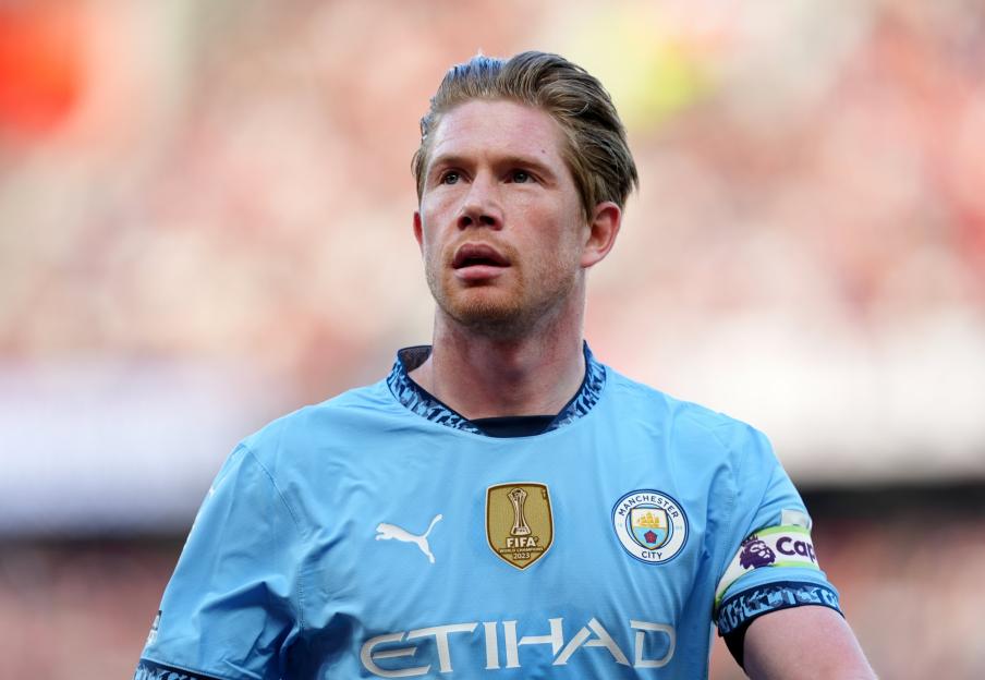 Kevin De Bruyne in a light blue Manchester City jersey with FIFA World Champions 2023 badge.
