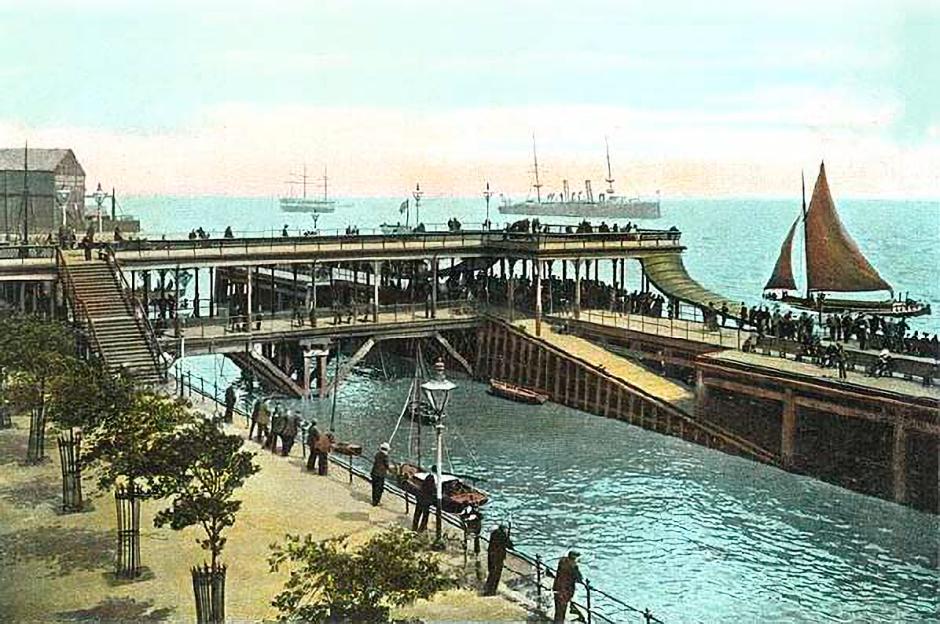 Illustration of Victoria Pier with people walking on it, boats in the water, and larger ships in the distance.