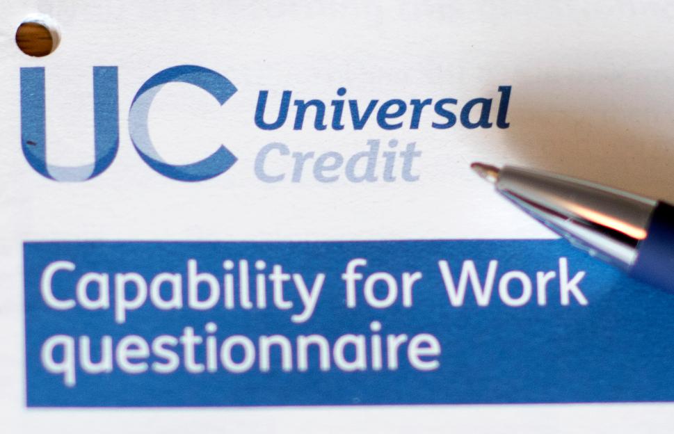 Close-up of a pen filling out a Universal Credit Capability for Work questionnaire.