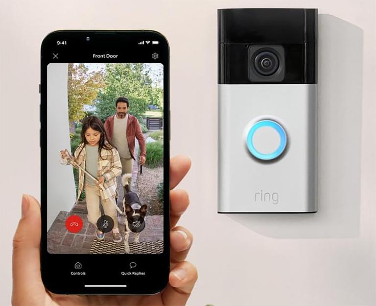 A Ring doorbell and a smartphone displaying a video feed of a girl, man, and dog at the front door.